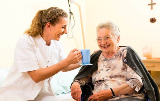 smiling senior woman and female nurse