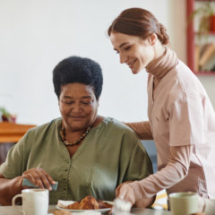 caregiver serving meal to the elder woman