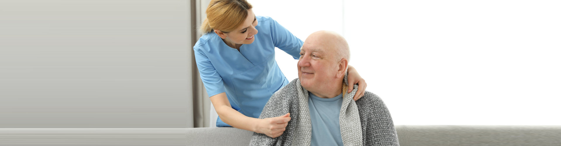 a caregiver woman looking at the elderly man
